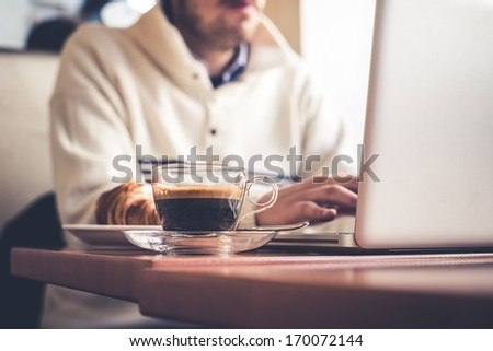 Multitasking Man Using Tablet, Laptop And Cellphone Connecting Wifi
