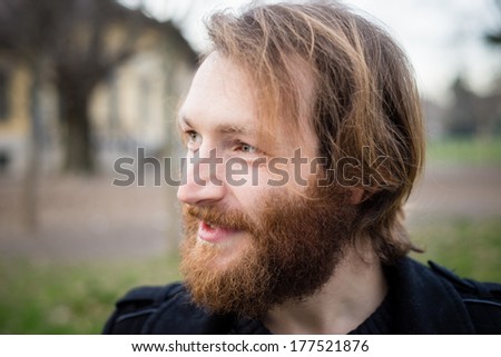 young hipster red bearded man at the park