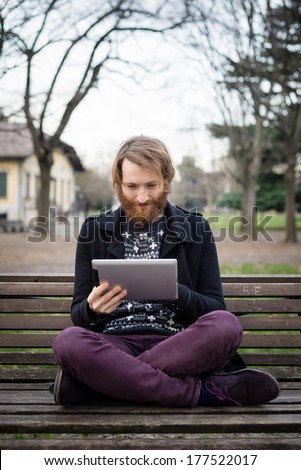 young hipster red bearded man at the park