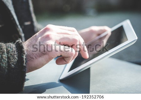 close up of hands man using tablet outdoor