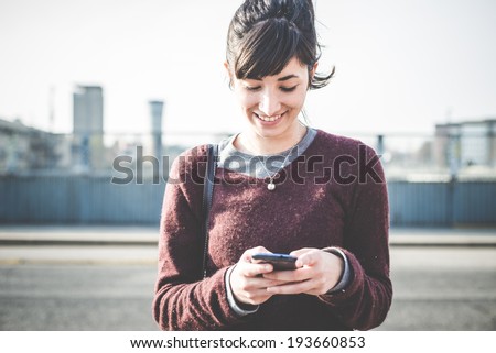 young beautiful hipster woman using smart phone in the city