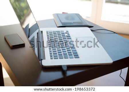 laptop, cellphone and graphic tablet on the table