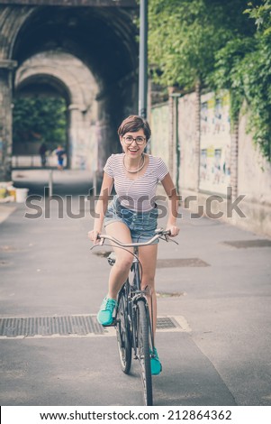 young hipster woman with bike in the city