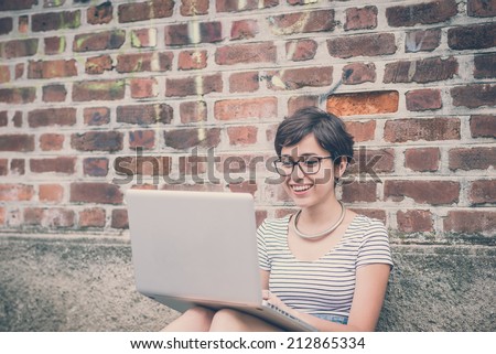 young hipster woman using notebook in the city
