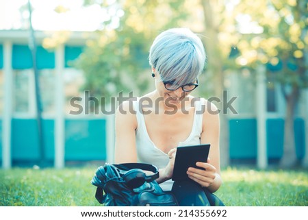 young beautiful short blue hair hipster woman using tablet device in the city