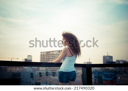 young beautiful long curly hair hipster woman in the city