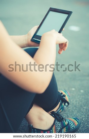 close up of woman hand using technological tablet device outdoor