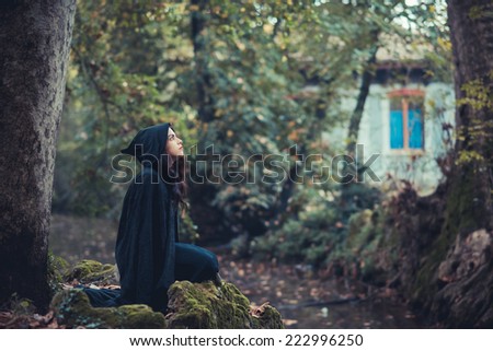 beautiful dark vampire woman with black mantle and hood halloween