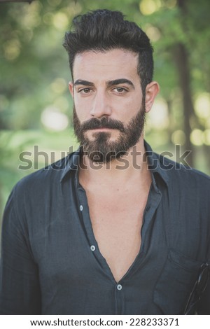 young handsome attractive bearded model man in the woods