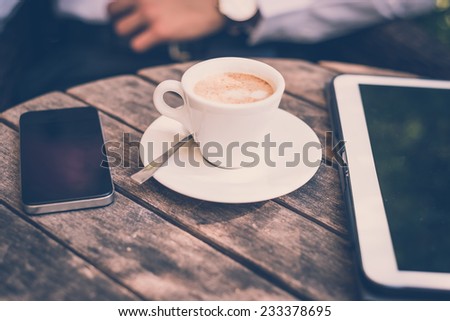 cup of coffee tablet and smart phone on wooden table