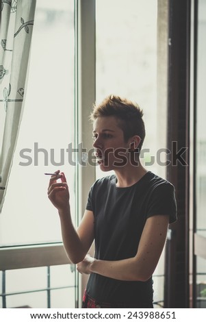 young lesbian stylish hair style woman smoking at home