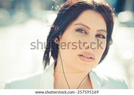 beautiful long black hair elegant business woman with earphones in the city