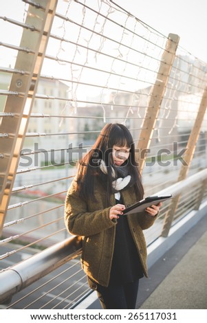 young beautiful asian hipster woman in the city - using device wireless tablet online
