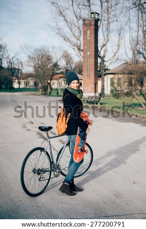 young beautiful hipster sporty blonde woman in town with bike