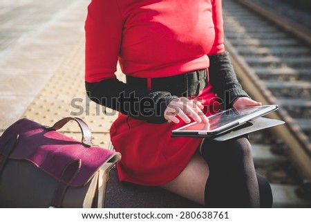 close up hands woman using tablet at the station waiting for train