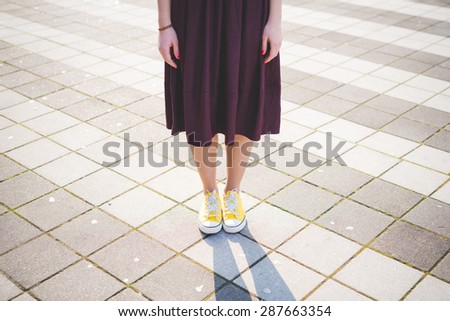 close up of modern young woman legs with skirt and yellow shoes