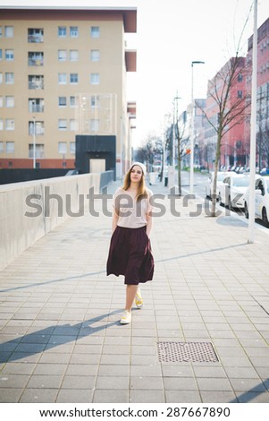 young beautiful blonde hipster woman in the city walking