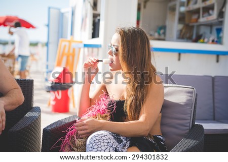 young beautiful brazilian woman at the beach bar eating icecream in summertime - happy hour, relax concept