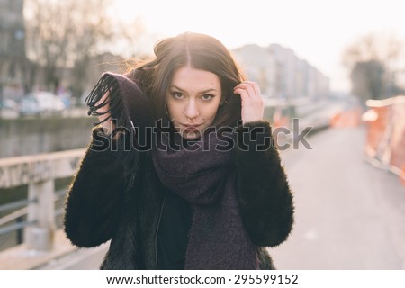 Young beautiful brunette caucasian girl walking down the street in the city