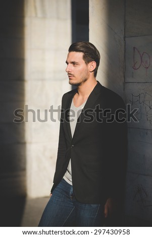 Knee figure of a young handsome italian boy posing in the city