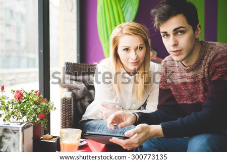 young beautiful couple lovers sitting at the bar using wireless tablet connected online - relax, social network, technology concepts