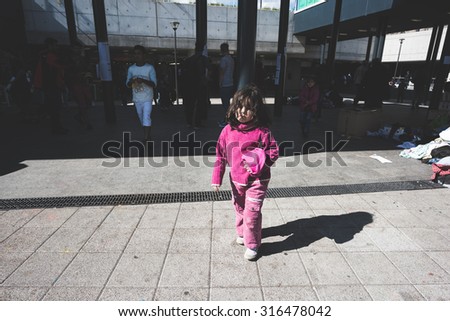 BUDAPEST - SEPTEMBER 7 : War syrian refugees at the Keleti Palyaudvar Railway Station on 1 September 2015 in Budapest, Hungary. Child walking outside the railway station, tired and hungry.