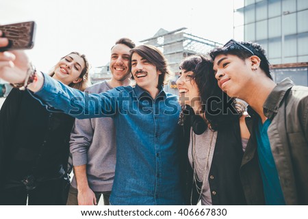 Group of young multiethnic friends taking a selfie with smart phone handhold , having fun - friendship, relaxing concept