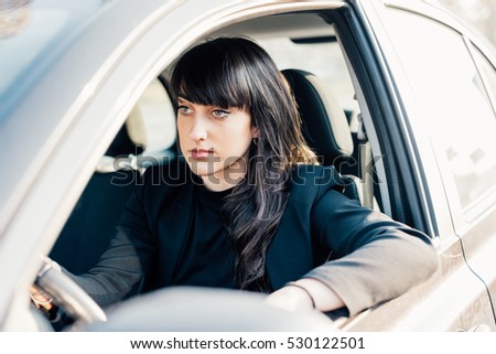 young handsome caucasian brown hair woman sitting on his car driving, looking straight, serene - traveling, transport concept