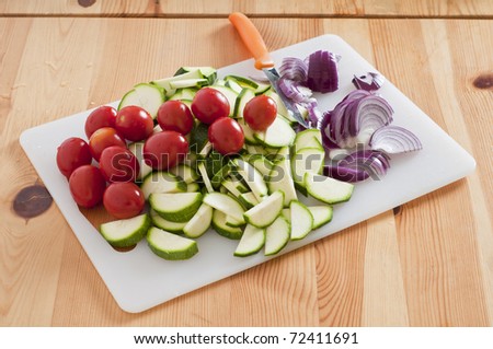 zucchini tomatoes and onions on cutting board