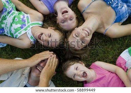 Father, mother and their four daughters have some fun in the backyard.