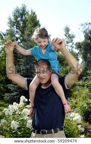 Father and his little daughter play in the backyard.