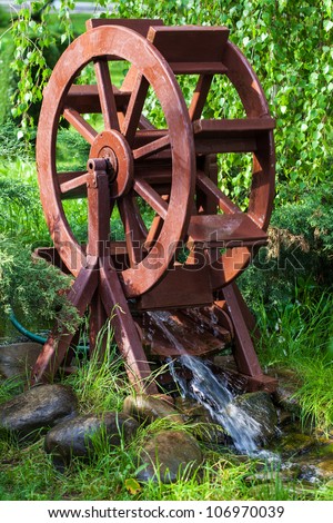 Decorative water wheel in the garden, element of modern landscape design