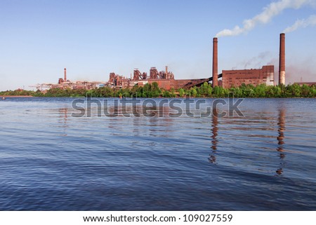 Panorama of metallurgical works reflected on water. Industrial landscape