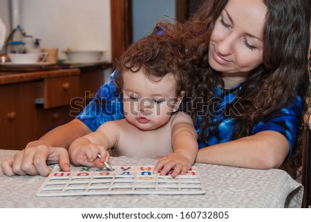 Baby girl plays with her mom in alphabet