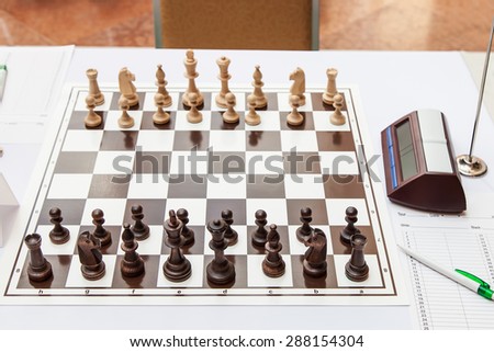 Chess board with wooden figures at the beginning of the chess tournament