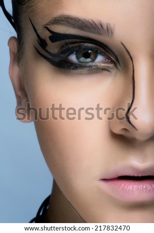 Close-up shot of young woman face with futuristic  makeup