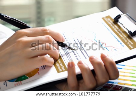 Accounting. Woman's hand with a pen writing on paper