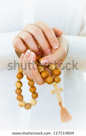 Woman\'s hand with a rosary and a cross