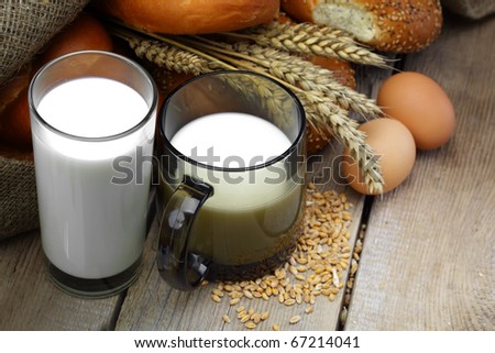 Glass of milk with wheat bread and chicken eggs