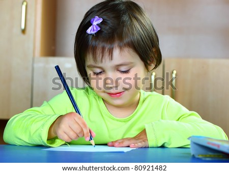 Beautiful smiling girl draws pencil