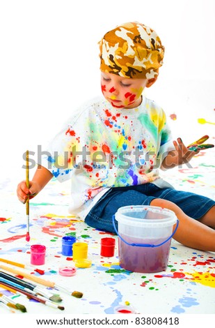 Smiling boy paints paints