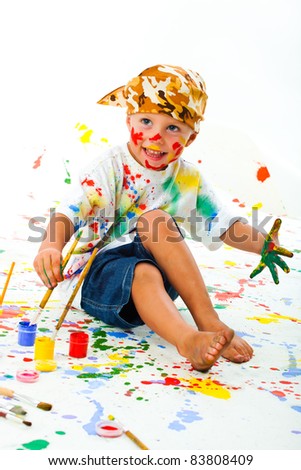 Smiling boy paints paints