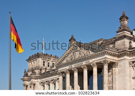 Reichstag building in Berlin, Germany with the German flag. The Reichstag is the meeting place of the Bundestag, the German parliament.