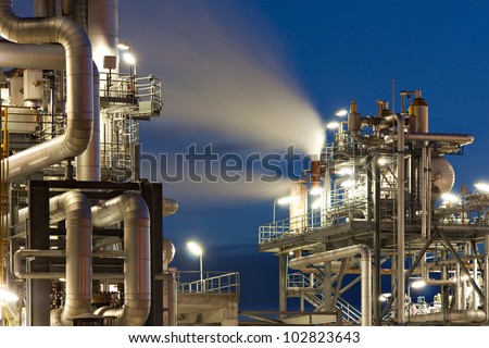 Oil refinery with water vapor in Hamburg, Germany, petrochemical industry night scene