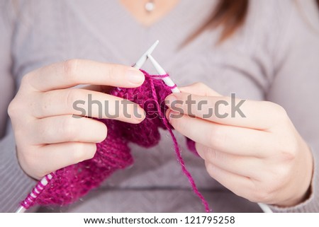 Hands of a young woman knitting wool