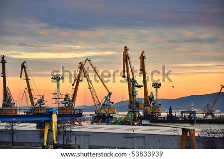Industrial black sea port Burgas, Bulgaria with a lot of cranes, cabins, boxes and tanks on beautiful orange sunset