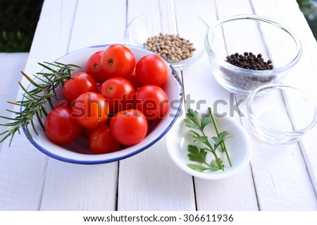 Cherry tomatoes, pepper, parsley, rosemary and salt on white background