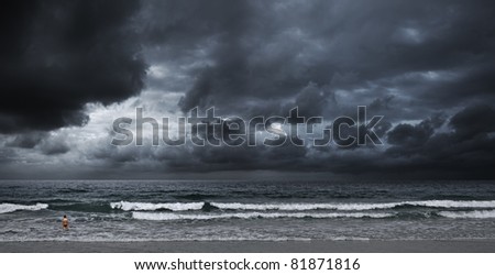 Stormy ocean. A boy is going to swim. Panoramic shot.