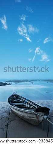 Wooden boat on the beach at dawn. Long exposure shot, vertical panorama in high resolution.