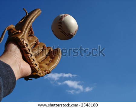 View of a hand in baseball glove reaching out to make the catch View of a hand in baseball glove reaching out to make the catch